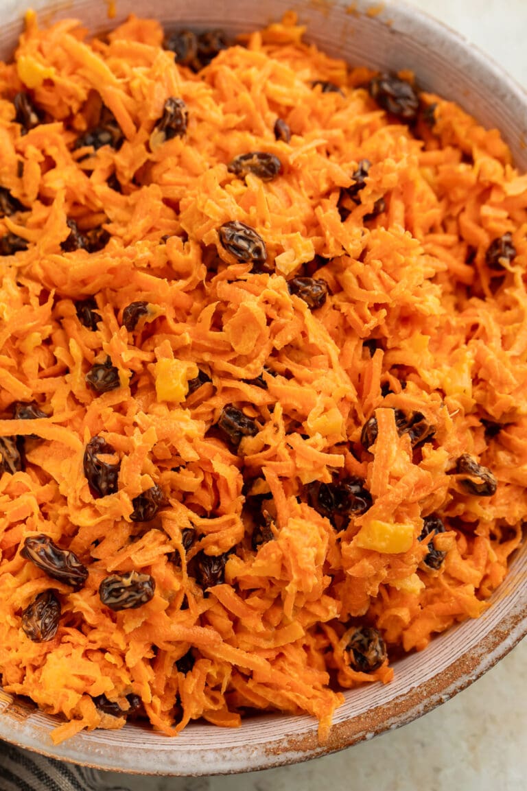 Close-up of a large bowl of carrot raisin salad.