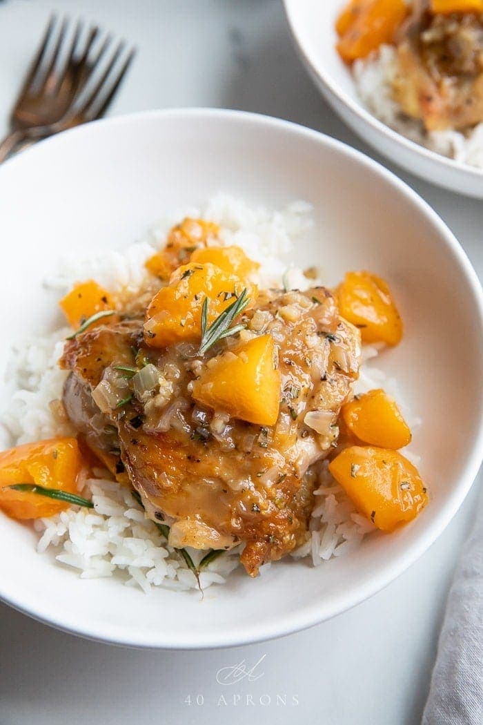 Apricot chicken over white rice in a white bowl