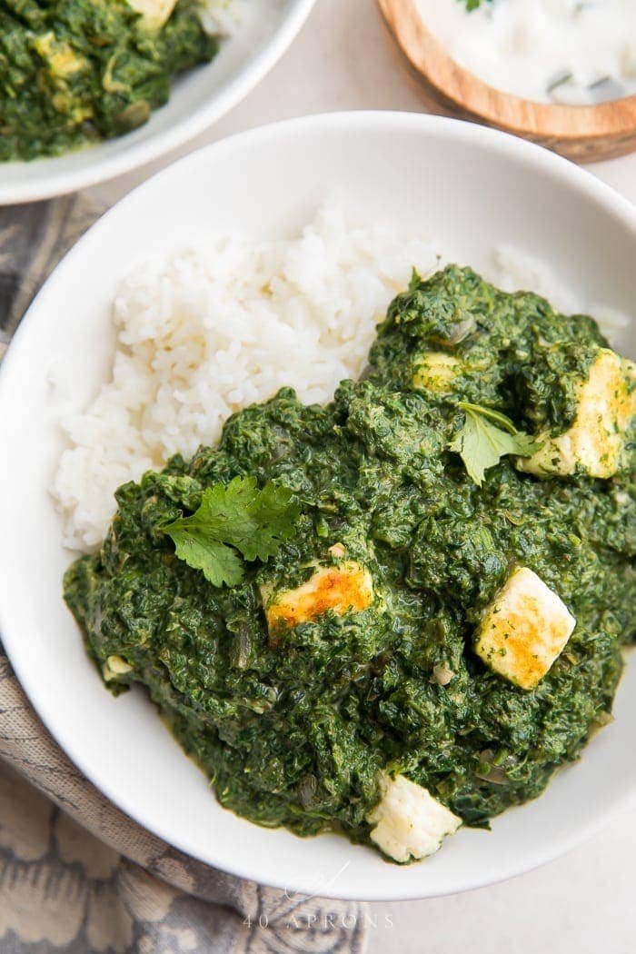 A bowl of palak paneer over rice