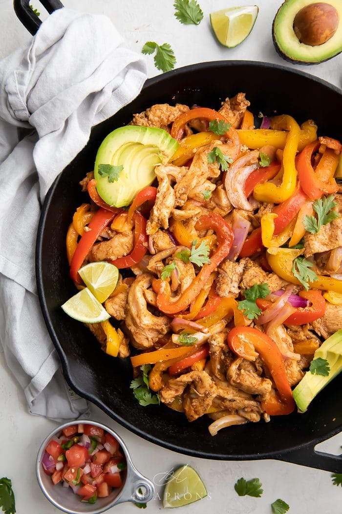 chicken fajita served in a skillet with garnishes