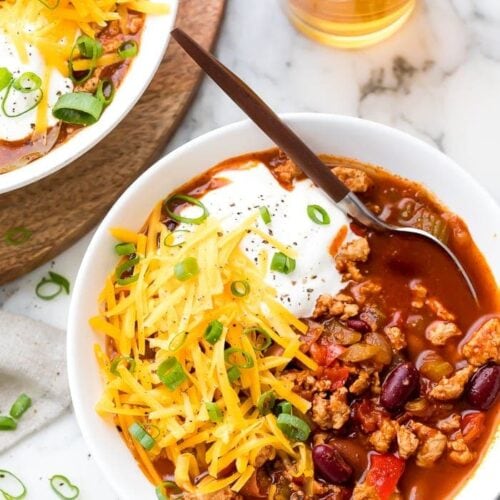 Turkey chili served in a white bowl with toppings