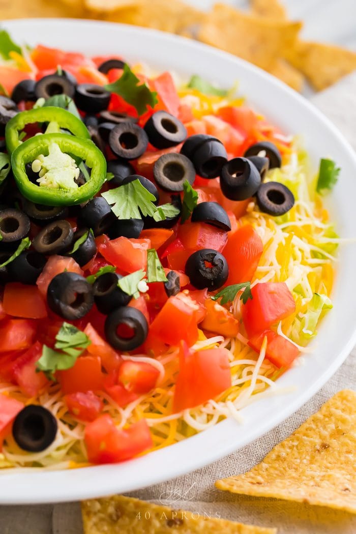 A taco dip served in a white bowl