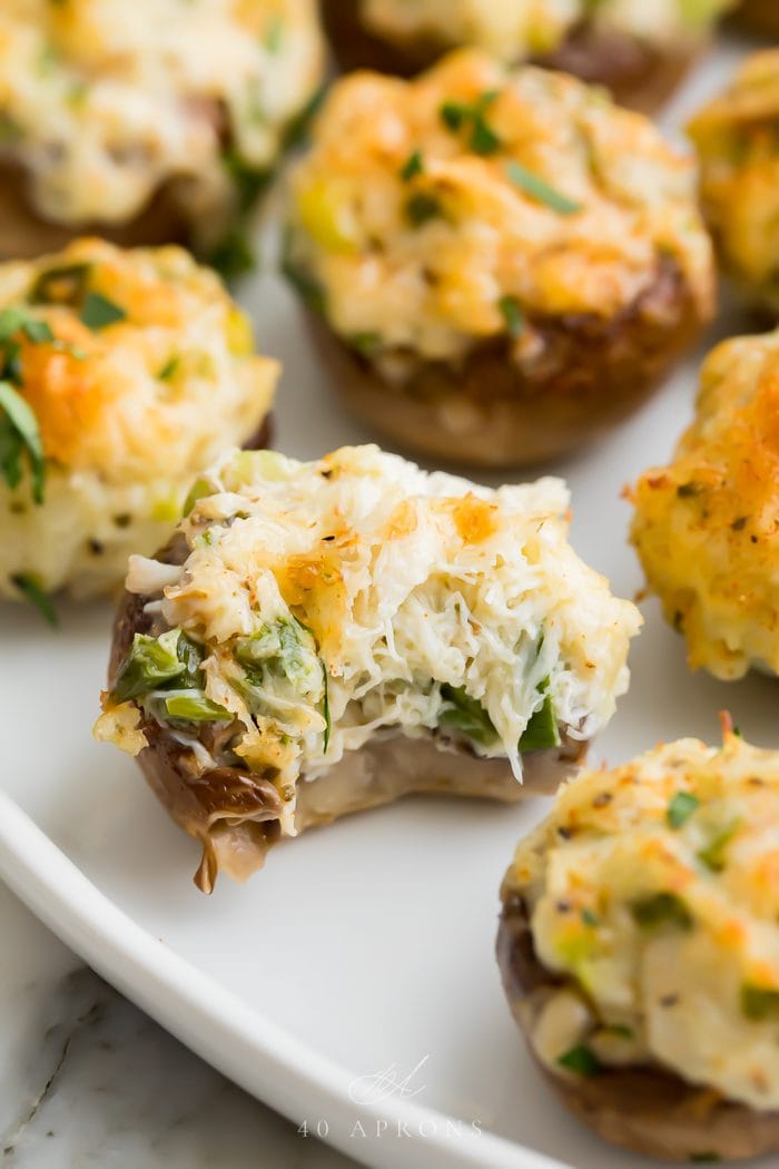 A crab stuffed mushroom with a bite taken out of it