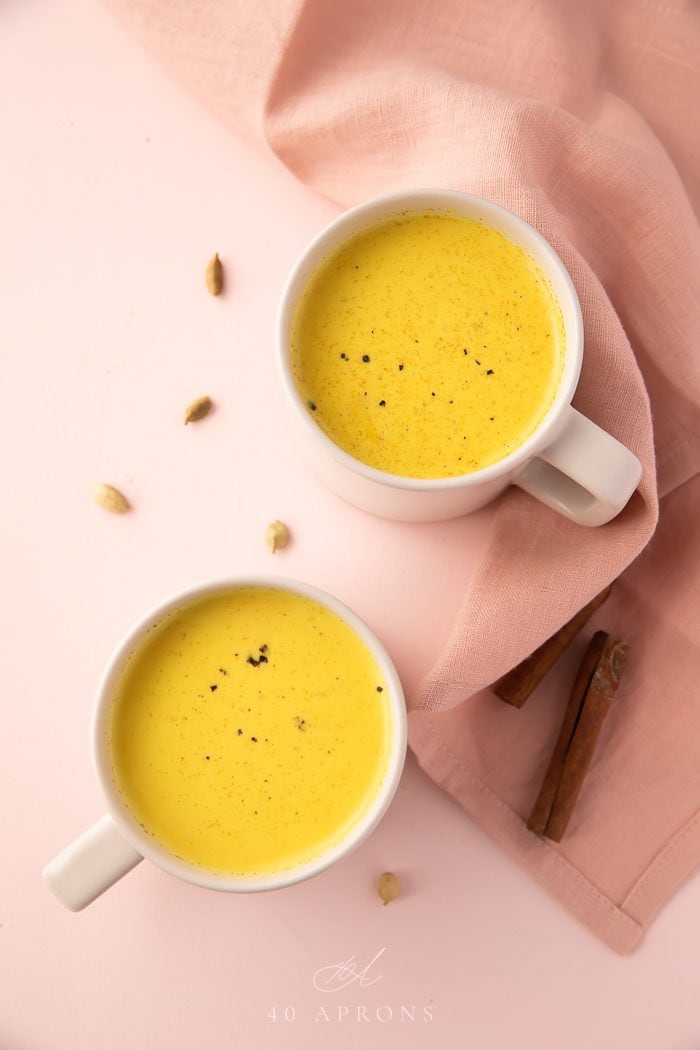 Golden milk served in two white mugs