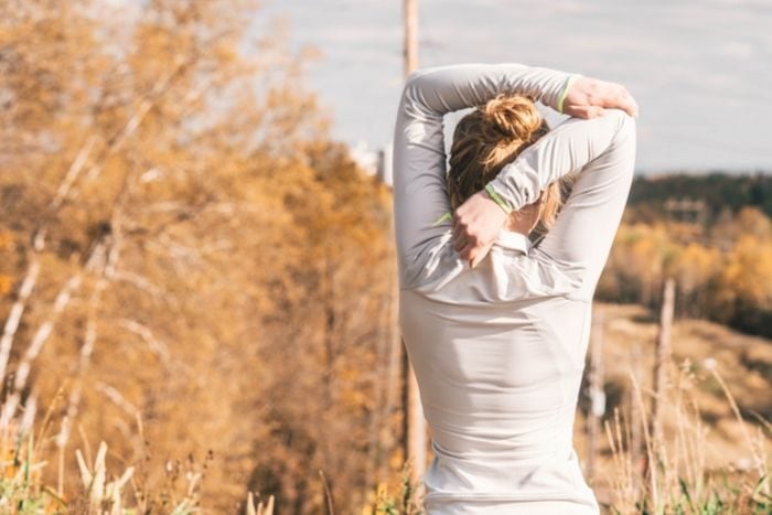 a blonde woman stretching before going on a run 