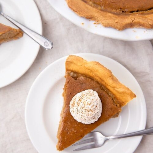 A slice of paleo pumpkin pie on a white plate