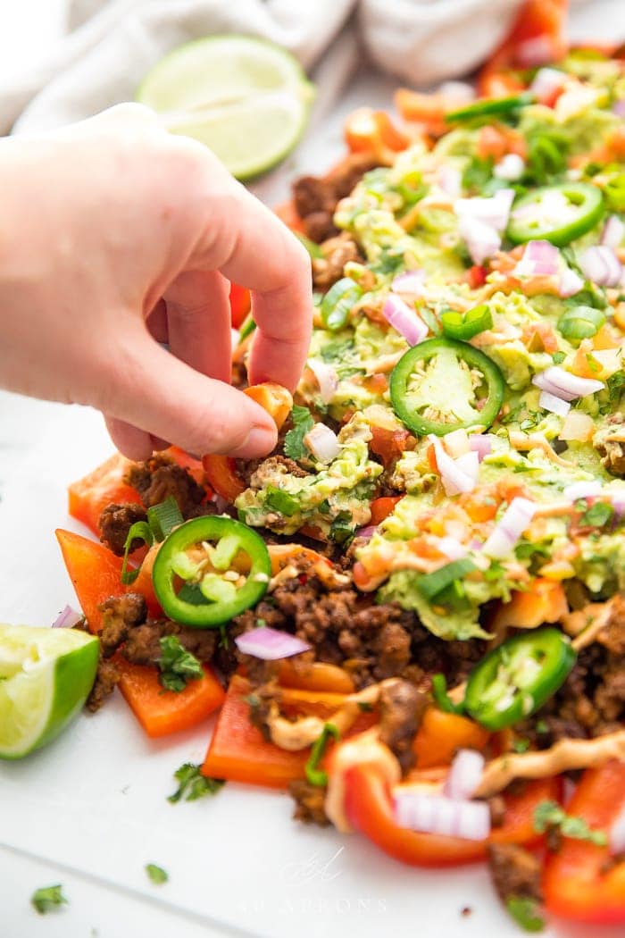 A hand picking fomr the bell pepper nachos