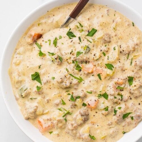 Cheeseburger soup in a white bowl with a spoon