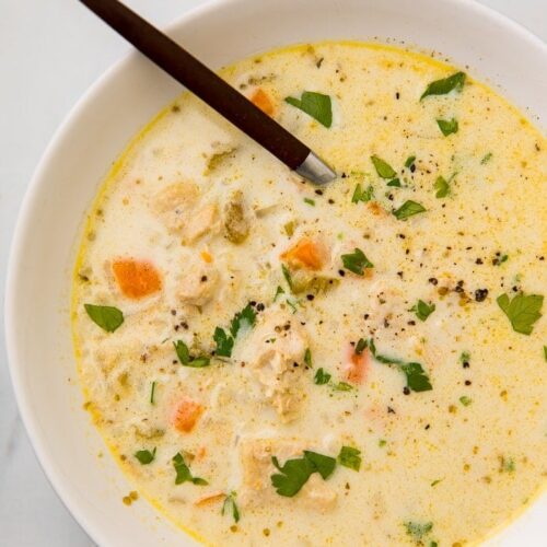 Chicken and rice soup garnished with fresh herbs