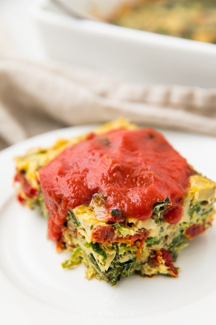 Italian breakfast casserole served on a white plate with red sauce