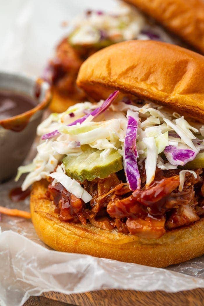 BBQ jackfruit sandwich on brioche bun with coleslaw and pickles