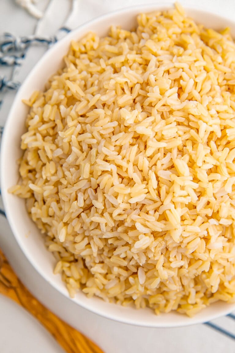 Top down view of a large white bowl holding a large mound of fluffy, fully cooked Instant Pot brown rice.