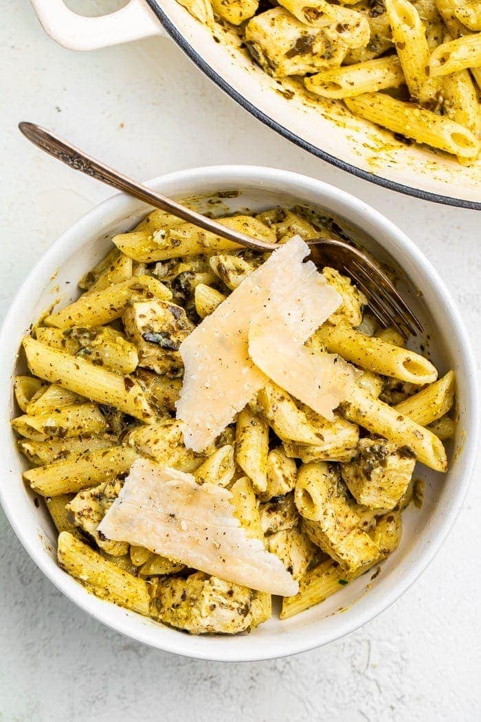 One-pot chicken pesto pasta in a bowl topped with Parmesan cheese