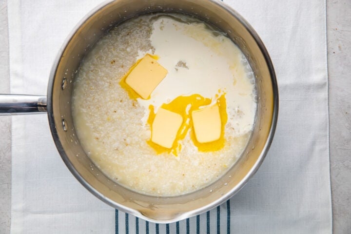 Simmered grits, 3 tablespoons butter, and a little heavy cream in a silver saucepan.