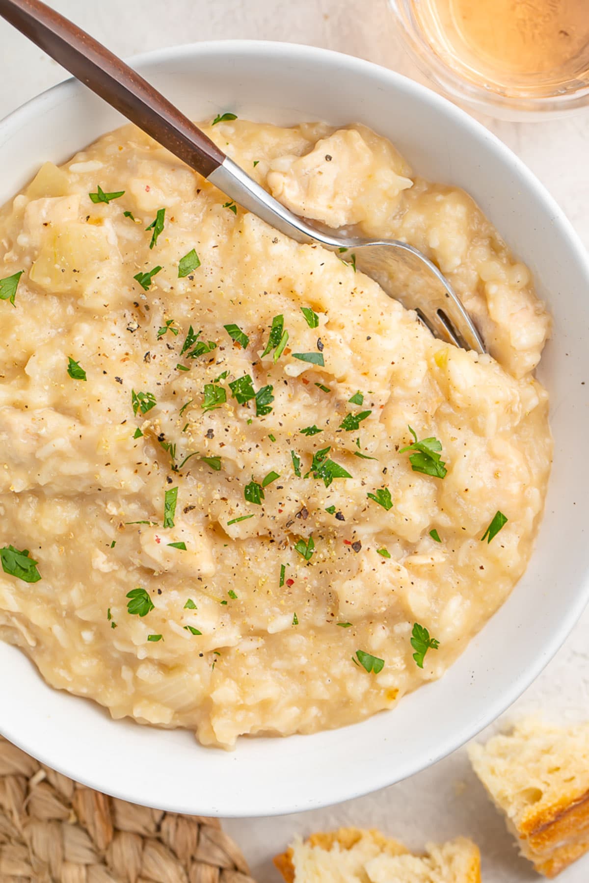 Overhead shot of a large white bowl of creamy Crockpot chicken and rice.