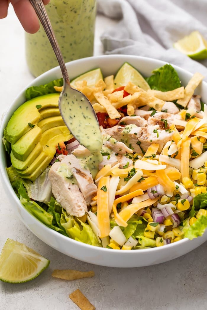 Cilantro lime dressing being drizzled over salad