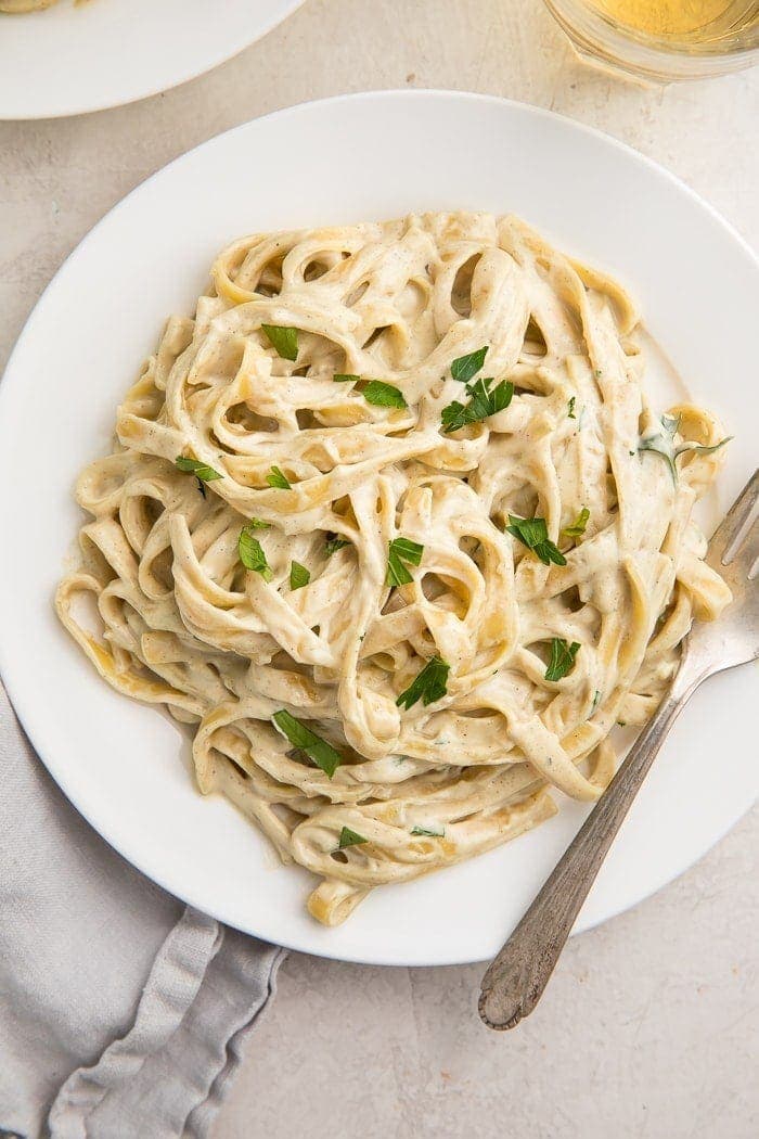 White plate of pasta with vegan alfredo sauce