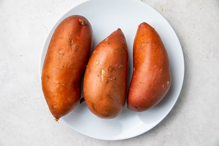 Three sweet potatoes on a white plate