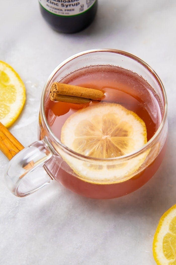 Overhead shot of elderberry hot toddy with lemon and cinnamon stick