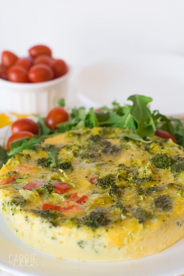 Vegetarian Instant Pot quiche in the foreground with a ramekin of cherry tomatoes in the background