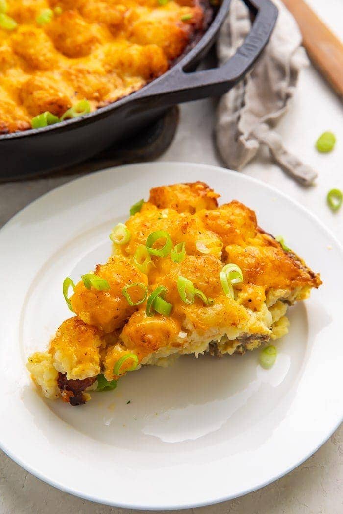 Wedge slice of tater tot breakfast casserole with sausage, egg, and cheese