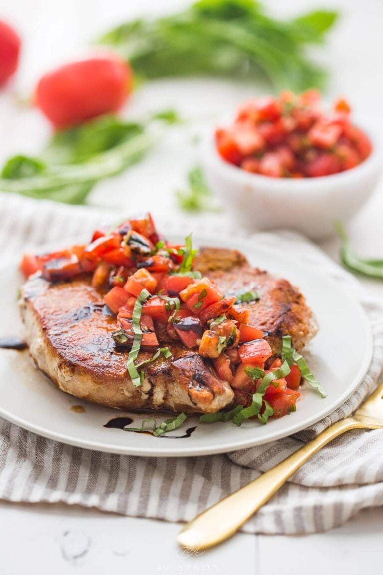 Bruschetta pork chops with balsamic vinaigrette on a white plate