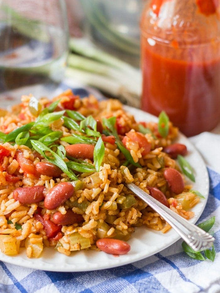 A plate of vegetarian slow cooker jambalaya with a fork on a blue and white tablecloth