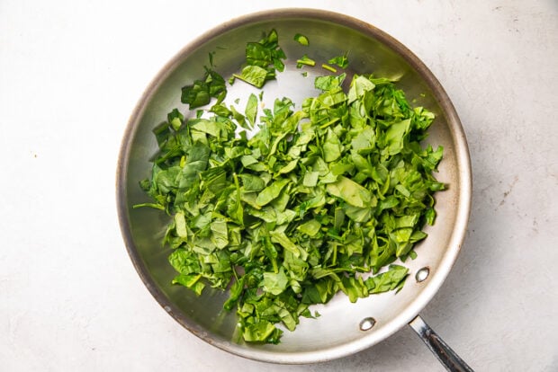 Silver pan with spinach, olive oil, and garlic