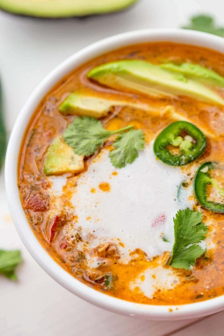 A white bowl of Whole30 crockpot taco soup with ground beef and sour cream