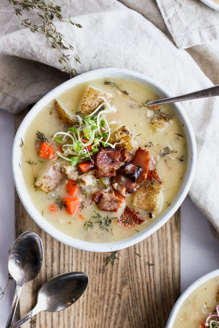 A misshapen bowl of clam chowder with garnish