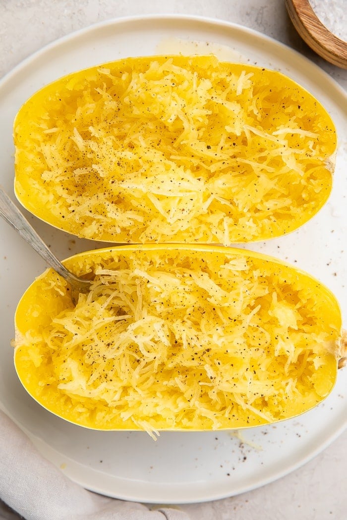 Two halves of vegan Instant Pot spaghetti squash on a white plate