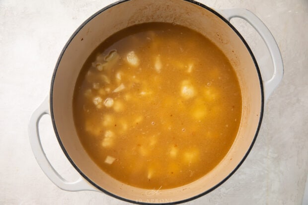 Chicken stock and onions in a dutch oven