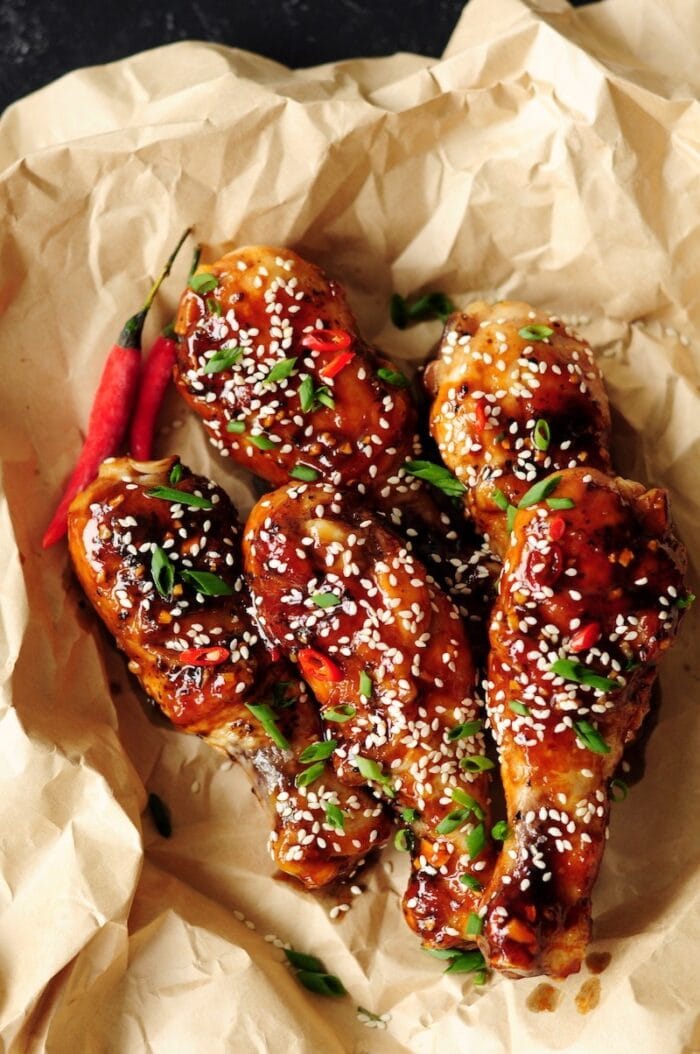 Marinated sous vide sticky chicken drumsticks in a paper lined basket