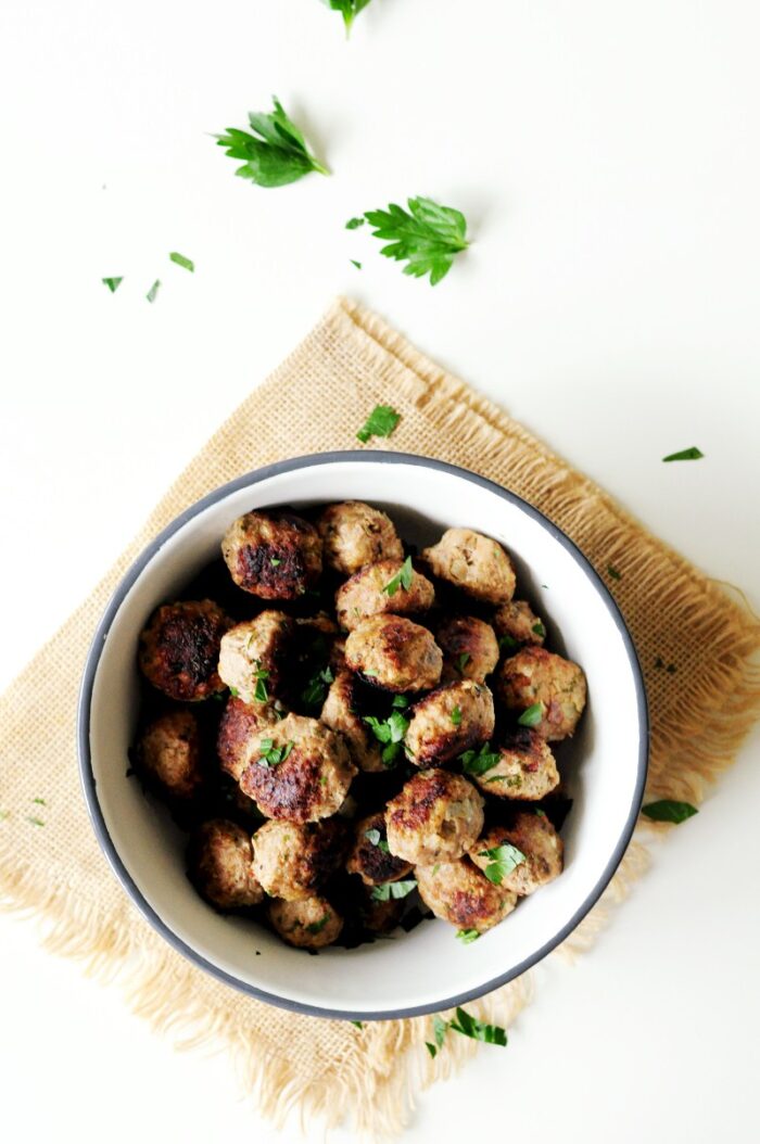 A bowl of Italian meatballs on a tan napkin