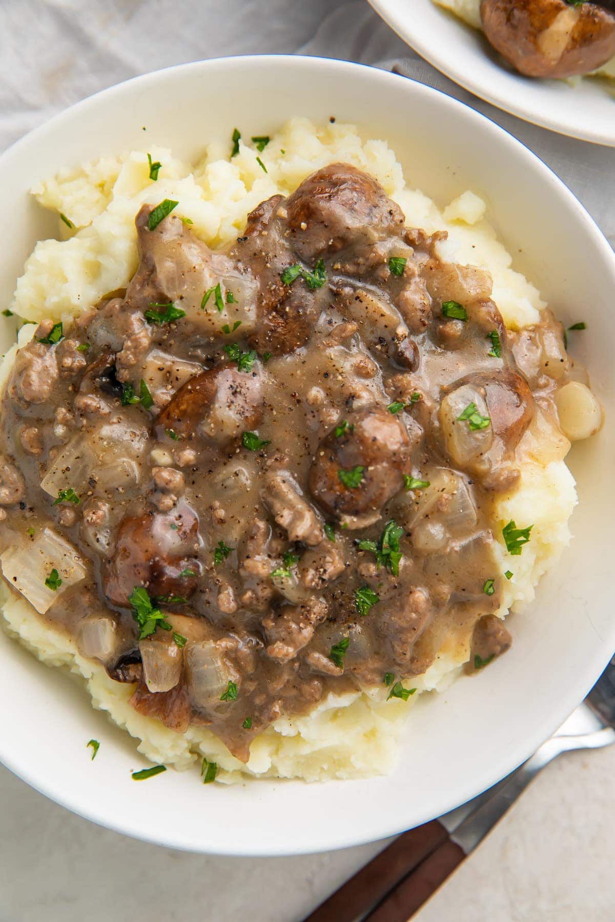 Close up overhead image of beef stroganoff on top of mashed potatoes