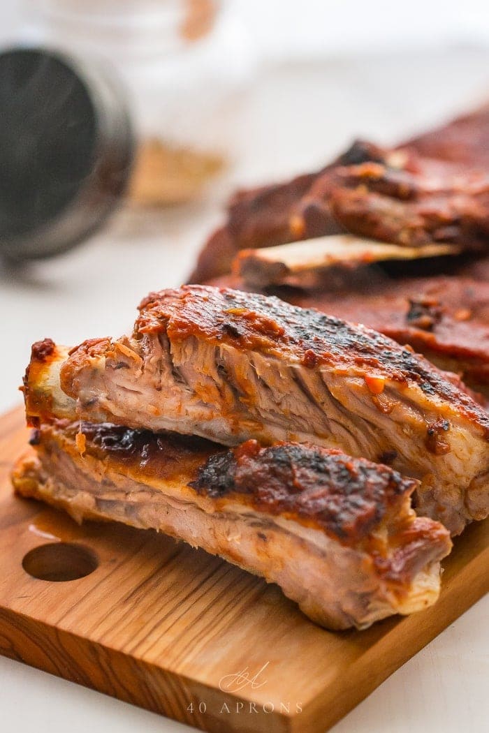 Baby back ribs cut apart on a wooden cutting board