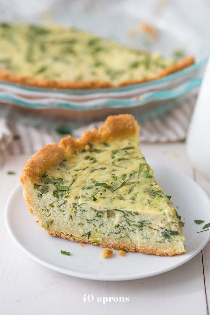 A wedge slice of crab quiche on a white plate