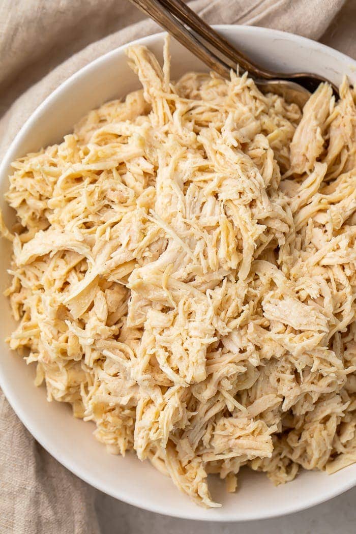 A white bowl of plain shredded chicken