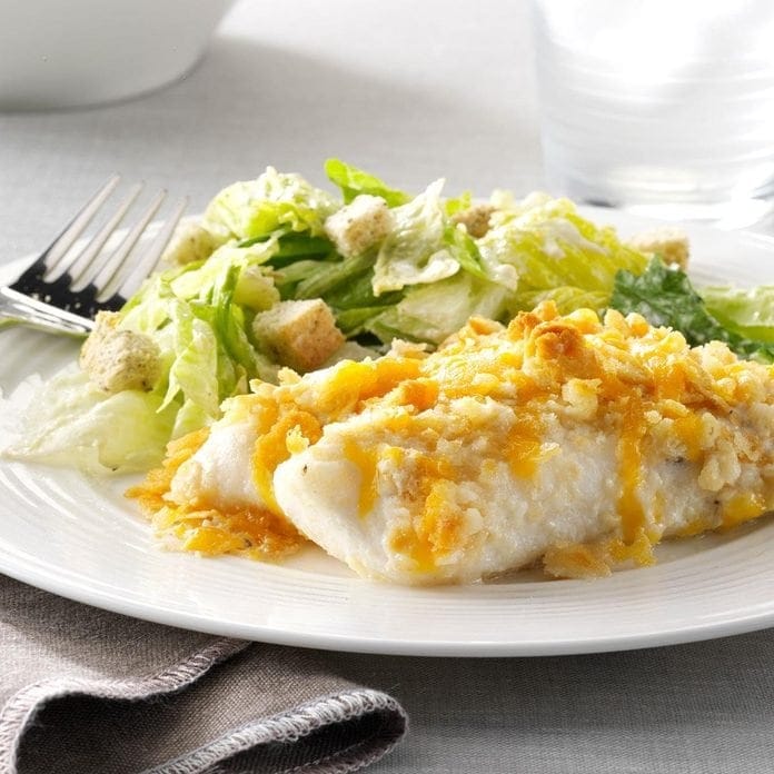 Fish and caesar salad on a white plate