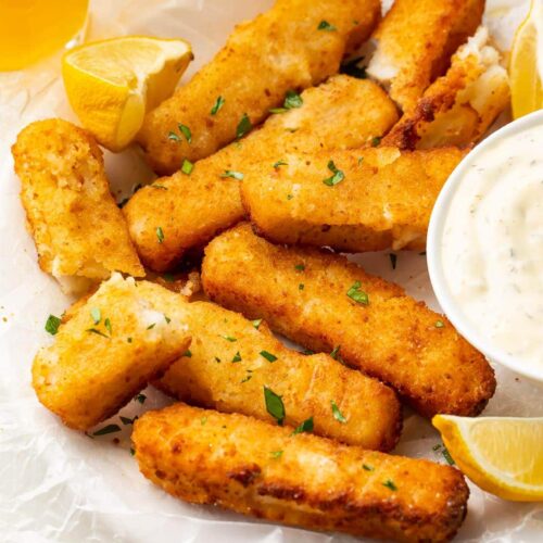 Air fried fish sticks on a white plate with dipping sauce