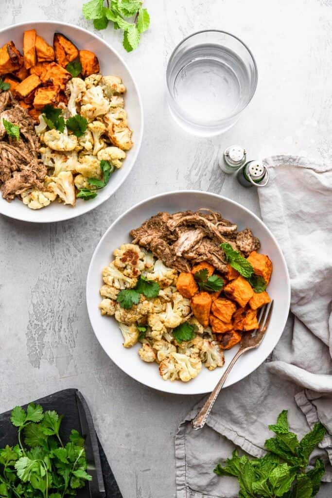 Bowls of tahini chicken on a light countertop