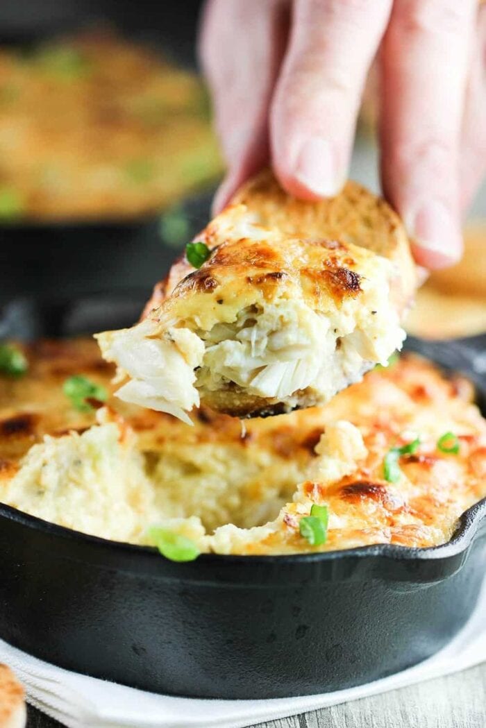 A slice of gratin being removed from a cast iron skillet