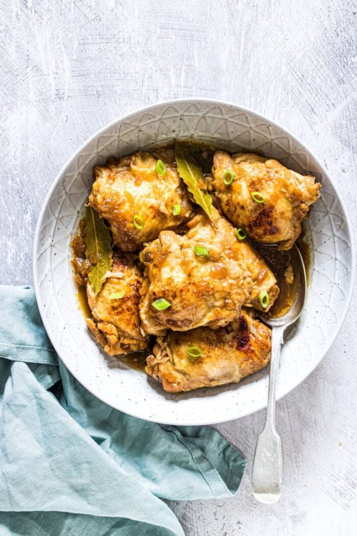 Large white bowl holding chicken adobo