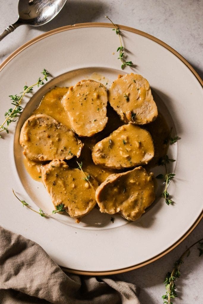 Garlic dijon pork tenderloin on a white plate