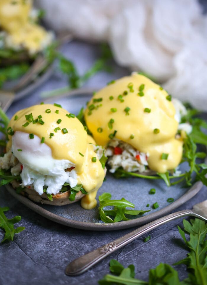 Two eggs benedict on a blue plate with grey trim