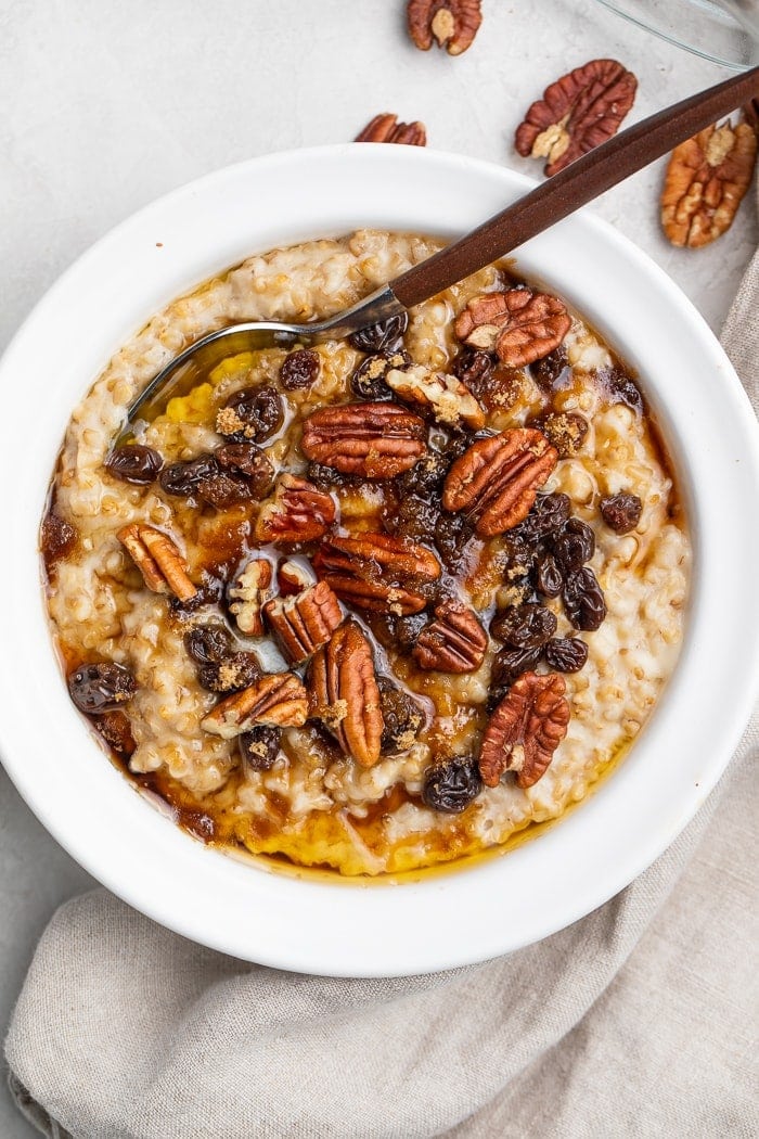 Instant Pot steel cut oats in a white bowl, topped with pecans