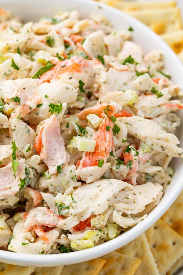 Crab salad in a bowl with an array of saltine crackers