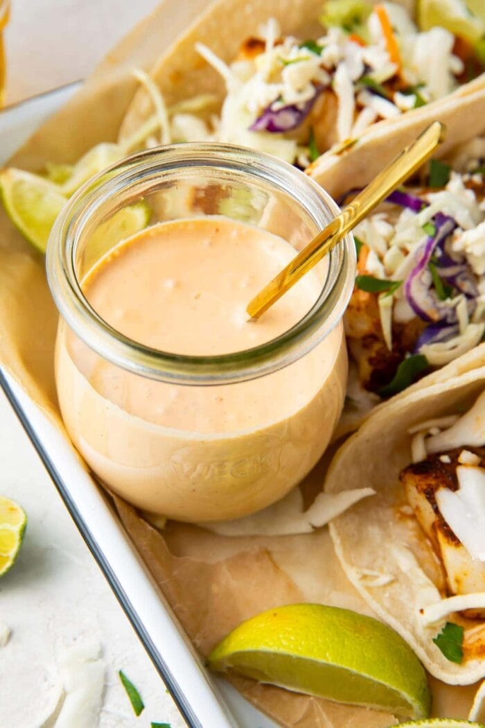 Fish taco sauce in a glass jar with a spoon