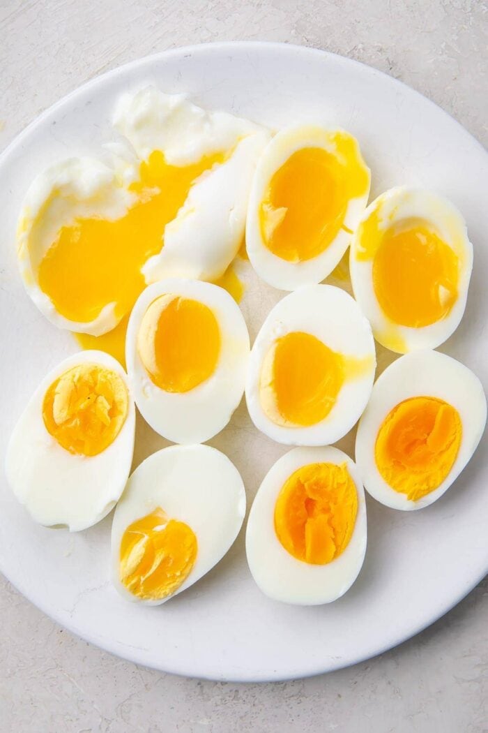 Various halved Instant Pot eggs on a white plate