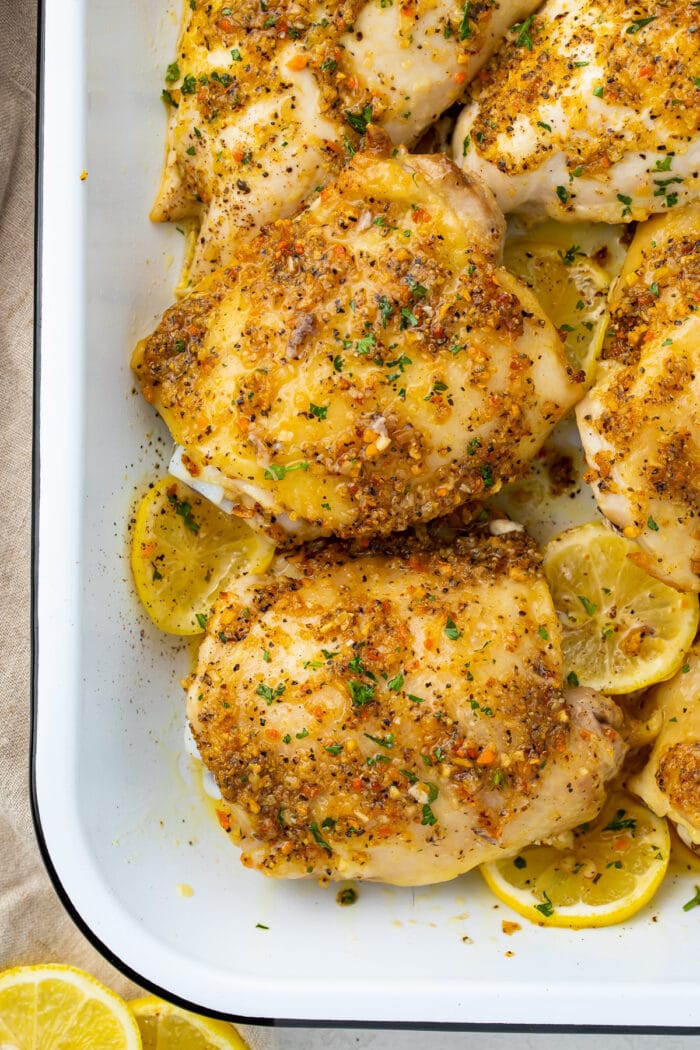 Lemon pepper chicken thighs in a white baking dish